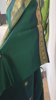 Green Silk Cotton saree with gold border and patterns on a white background
