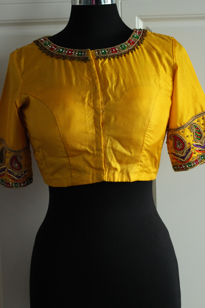 Yellow pure silk aari work with red, green and gold blouse